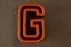 Vintage Industrial Letter "G" Black with Orange and Blue Paint, 2" tall (c.1940s) - thirdshift